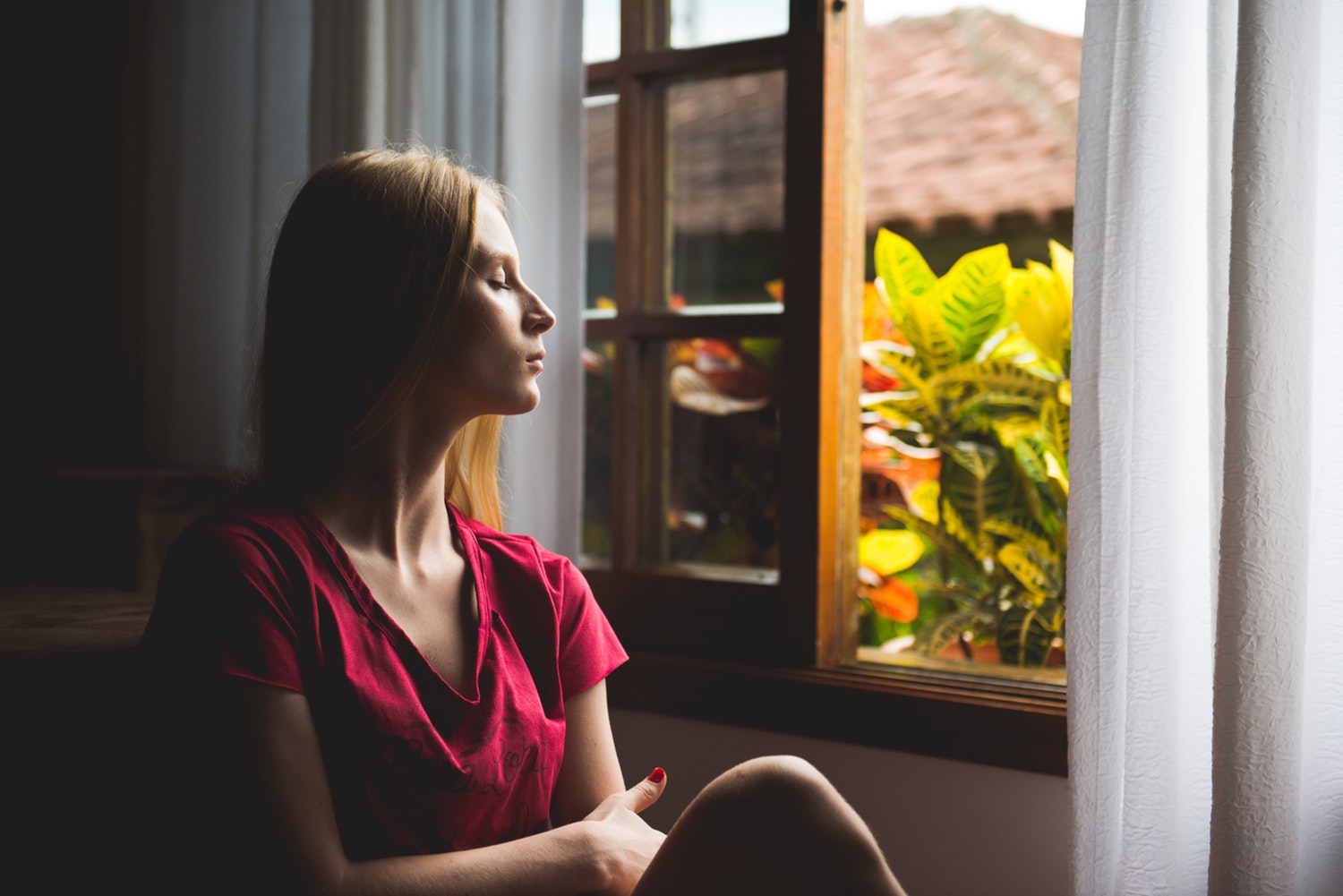 Photo of woman sitting by window